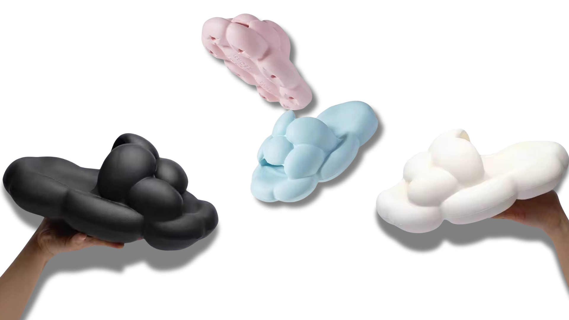 A creative display of three pairs of bubble slippers in black, pastel pink, and white, each uniquely designed with bulbous contours and held by human hands, showcasing their innovative and stylish appearance against a neutral background.